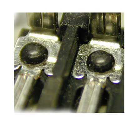 Eine größere Anzahl an Metalllaschen wird in einem Arbeitsschritt mittels Heißverstemmen fixiert. Die Pins messen ca. 1,3mm, die Dome ca. 2,2. Das Material ist ein PA6-GF30