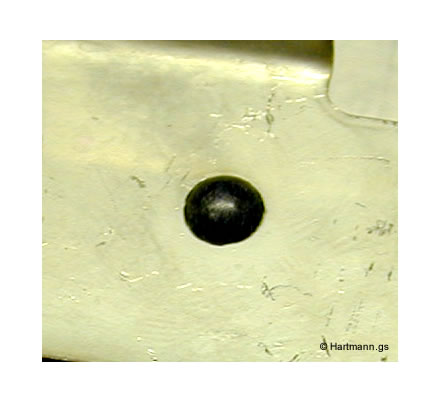 Ein Blech-Stanzteil wird durch einen heißverstemmten Pin in seiner Position fixiert. Der Pin misst vor der Verstemmung ca. 1,5mm. Der heißverstemmte Dom misst etwa 2,8mm. Das Material ist POM.